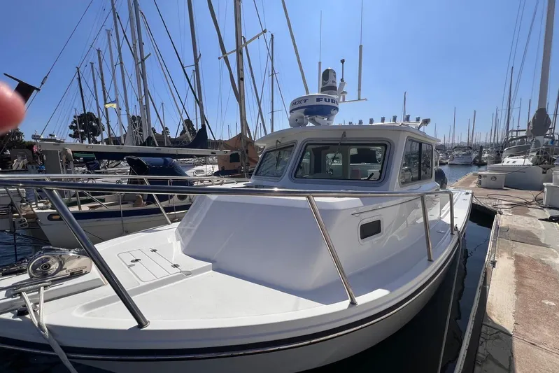 Sd Jam Yacht Photos Pics 2023 Parker 2820 XLD Sport Cabin boat docked at marina, surrounded by sailboats.