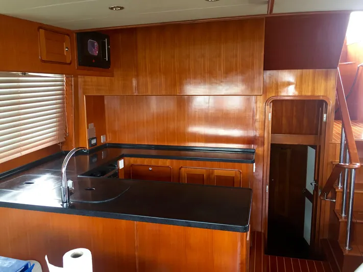 Mariposa Yacht Photos Pics 2012 Integrity 45 yacht kitchen with wooden cabinetry and black countertops.