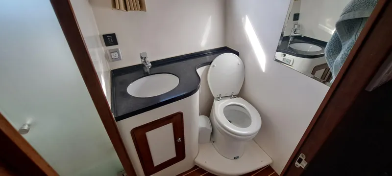 Mariposa Yacht Photos Pics Compact bathroom in a 2012 Integrity 45 boat with sink, toilet, and mirror.