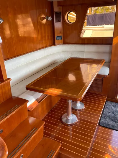 Mariposa Yacht Photos Pics Luxurious interior of 2012 Integrity 45 yacht with wooden table and white leather seating.