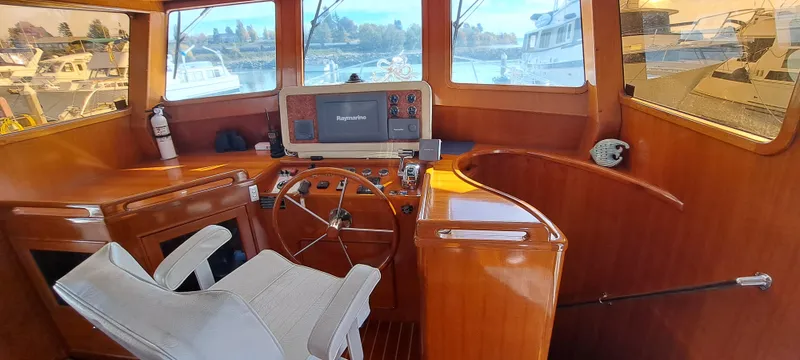 Mariposa Yacht Photos Pics Interior helm of a 2012 Integrity 45 boat with wooden finish and navigation equipment.