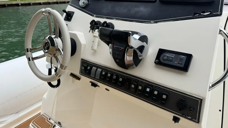 Hoko Yacht Photos Pics Control panel of a 2017 Nuova Jolly Princess boat with steering wheel and switches.