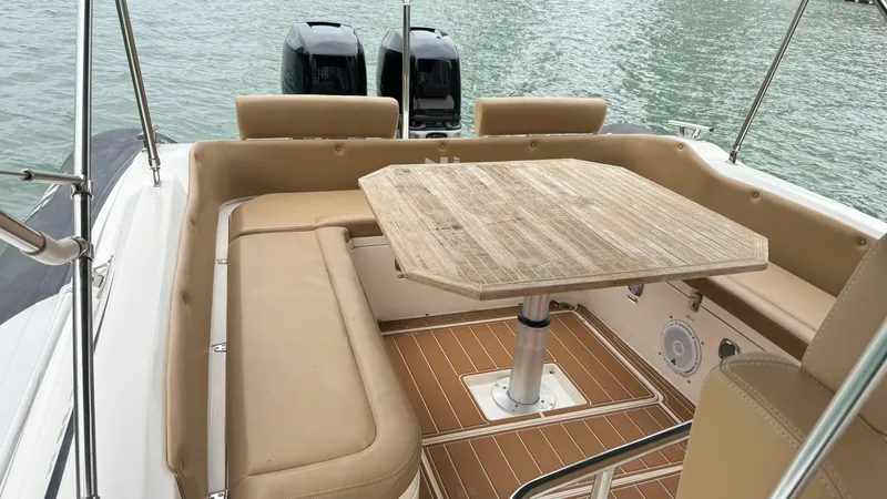 Hoko Yacht Photos Pics 2017 Nuova Jolly Princess boat interior with beige seating and wooden table.