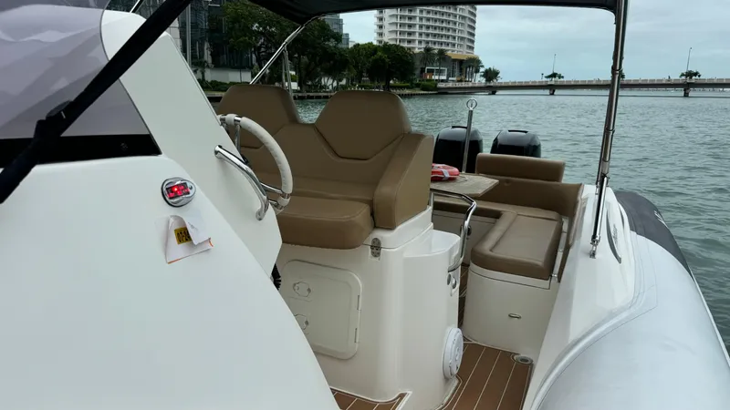 Hoko Yacht Photos Pics 2017 Nuova Jolly Princess boat interior with tan seating, steering wheel, and waterfront view.