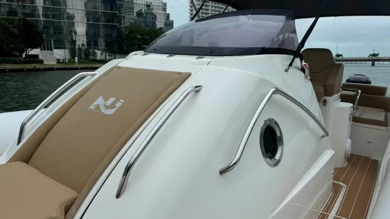 Hoko Yacht Photos Pics 2017 Nuova Jolly Princess boat with sleek design and tan seating, docked near modern buildings.