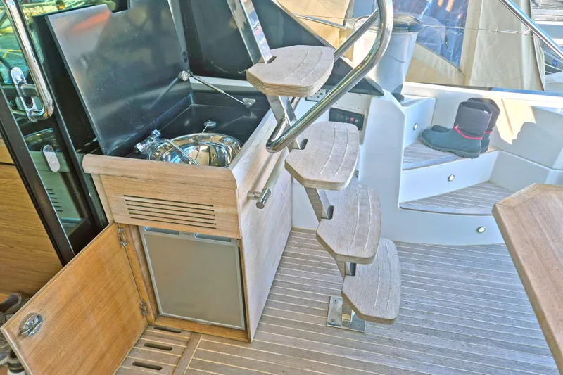  Yacht Photos Pics 2019 Beneteau Gran Turismo 50 Sportfly interior with wooden steps and compact kitchenette.