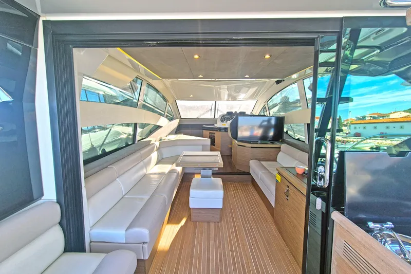  Yacht Photos Pics Luxurious interior of 2019 Beneteau Gran Turismo 50 Sportfly yacht with modern seating and wood flooring.