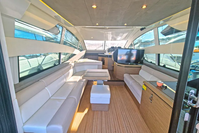  Yacht Photos Pics Luxurious interior of 2019 Beneteau Gran Turismo 50 Sportfly yacht with modern seating and wood flooring.
