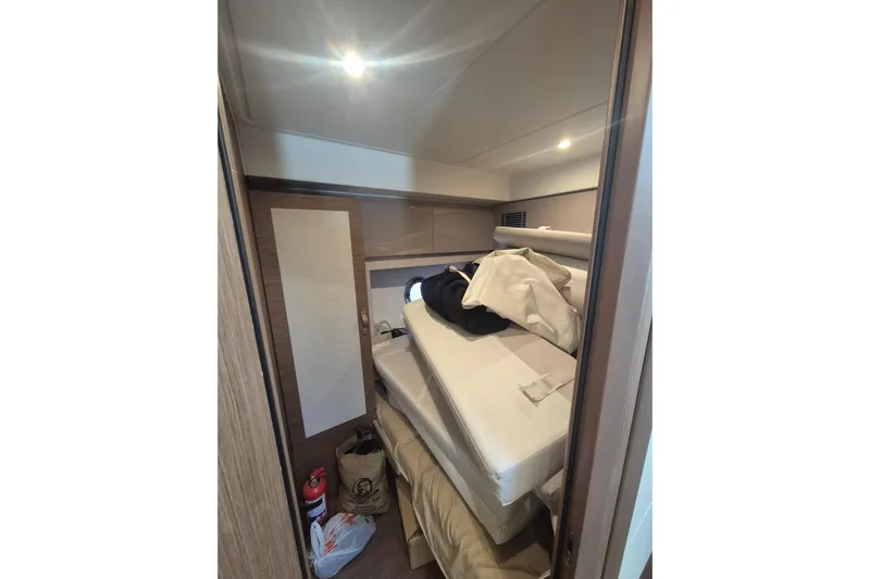  Yacht Photos Pics 2019 Beneteau Gran Turismo 50 Sportfly cabin with stacked cushions and storage items.