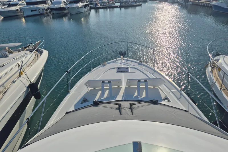  Yacht Photos Pics 2019 Beneteau Gran Turismo 50 Sportfly yacht docked in a marina, sunlit water.