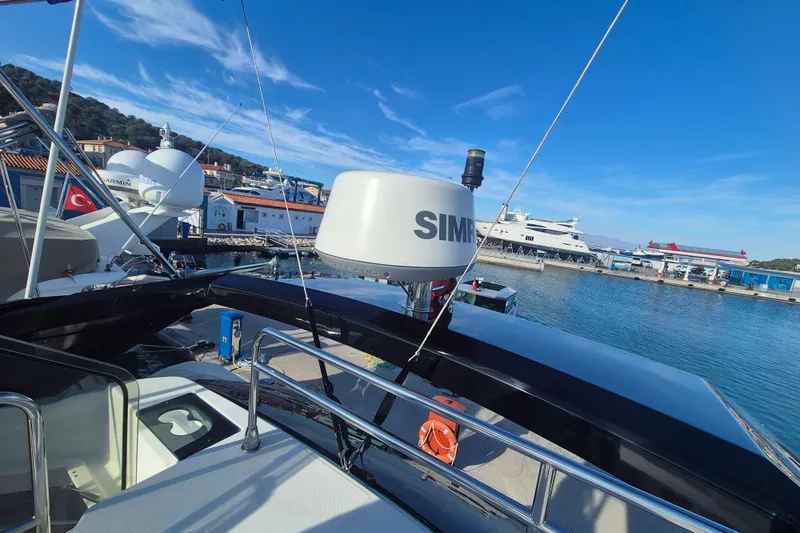  Yacht Photos Pics 2019 Beneteau Gran Turismo 50 Sportfly docked at a marina under clear blue skies.