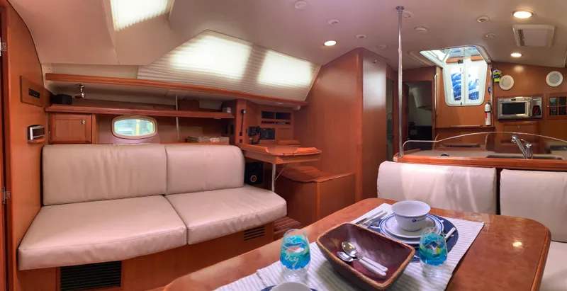 Flote About Yacht Photos Pics Interior of 2009 Hunter 45 Deck Salon yacht with modern furnishings and dining setup.