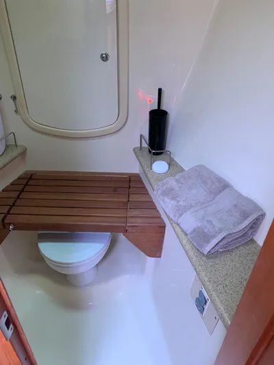 Flote About Yacht Photos Pics 2009 Hunter 45 Deck Salon bathroom with wooden seat, towels, and toiletries.