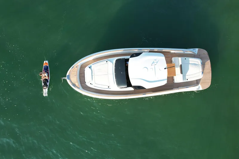  Yacht Photos Pics 2023 Solaris Power 44 Open yacht with person swimming nearby in clear water.