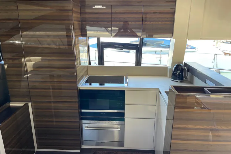  Yacht Photos Pics Modern kitchen interior on 2025 Ferretti Yachts 670, featuring sleek cabinetry and appliances.