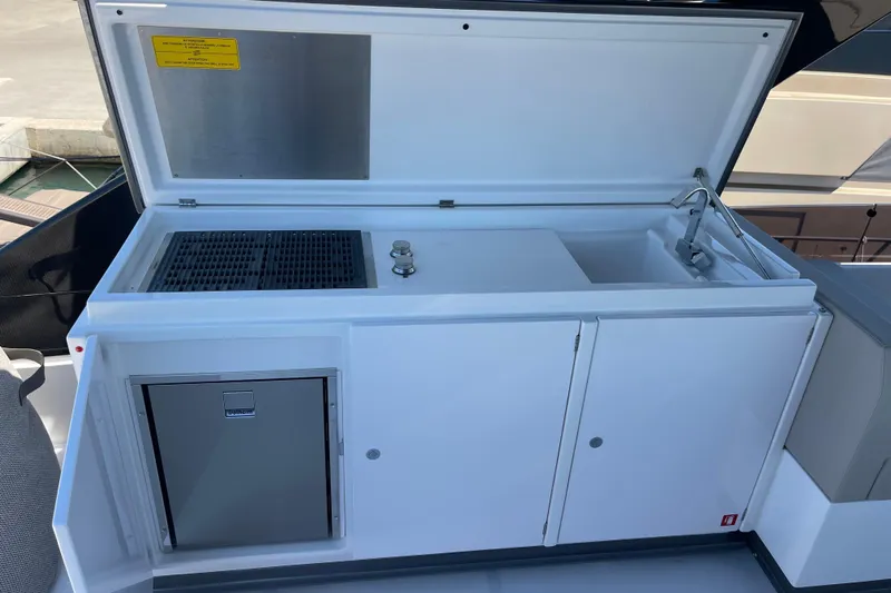  Yacht Photos Pics Outdoor kitchenette on 2025 Ferretti Yachts 670, featuring grill, sink, and storage.