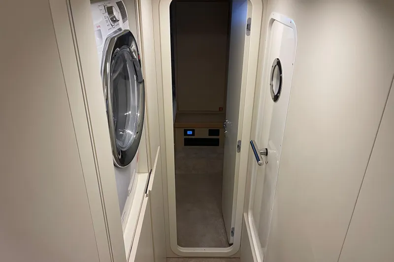  Yacht Photos Pics Laundry area inside 2025 Ferretti Yachts 670, featuring modern washing machine.