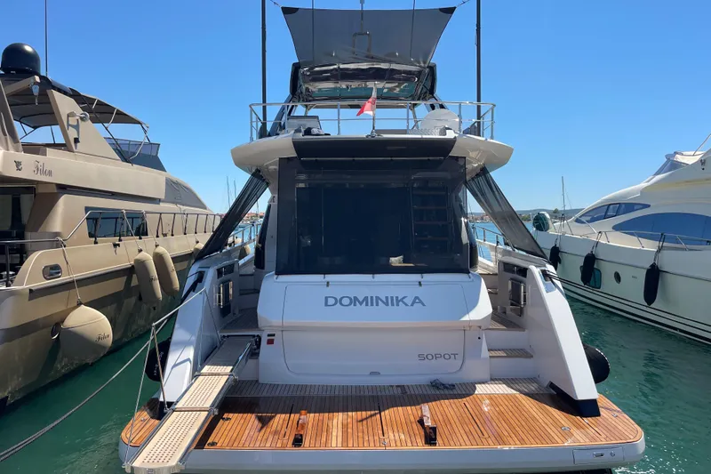  Yacht Photos Pics 2025 Ferretti Yachts 670 docked, rear view with wooden deck and clear sky.
