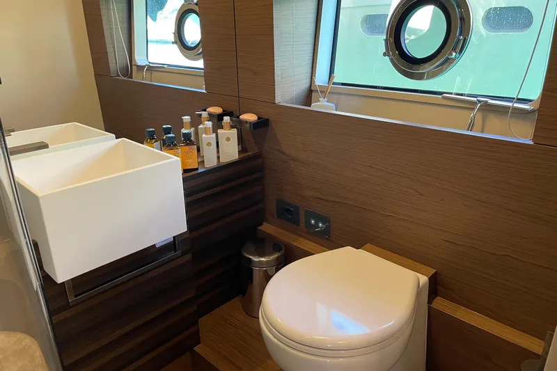  Yacht Photos Pics Luxurious bathroom in 2025 Ferretti Yachts 670, featuring modern fixtures and elegant wood paneling.