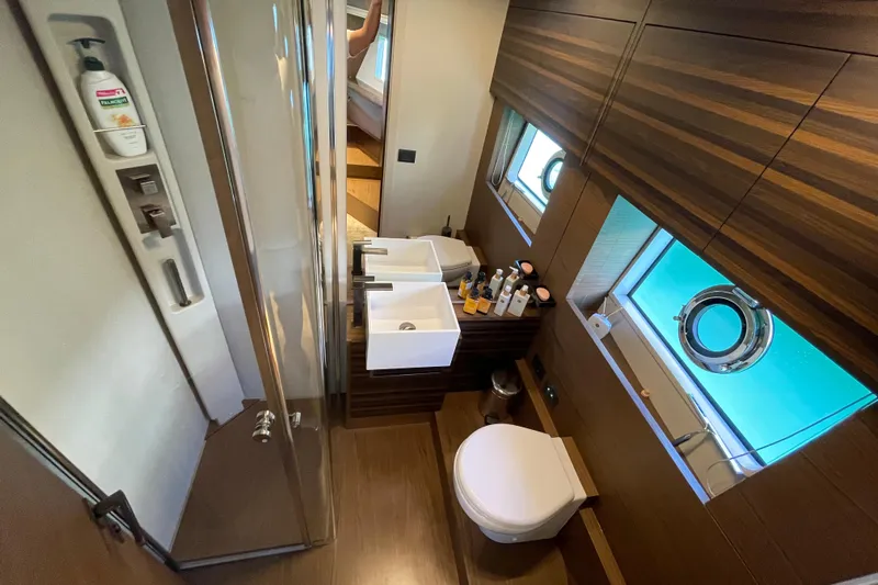  Yacht Photos Pics Luxurious bathroom in 2025 Ferretti Yachts 670, featuring modern fixtures and elegant wood paneling.