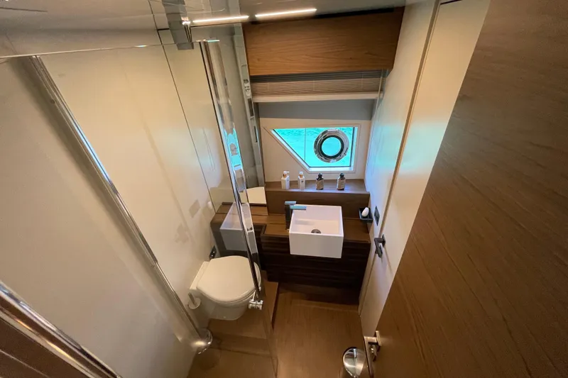  Yacht Photos Pics Luxurious bathroom interior of 2025 Ferretti Yachts 670 with modern fixtures and porthole window.