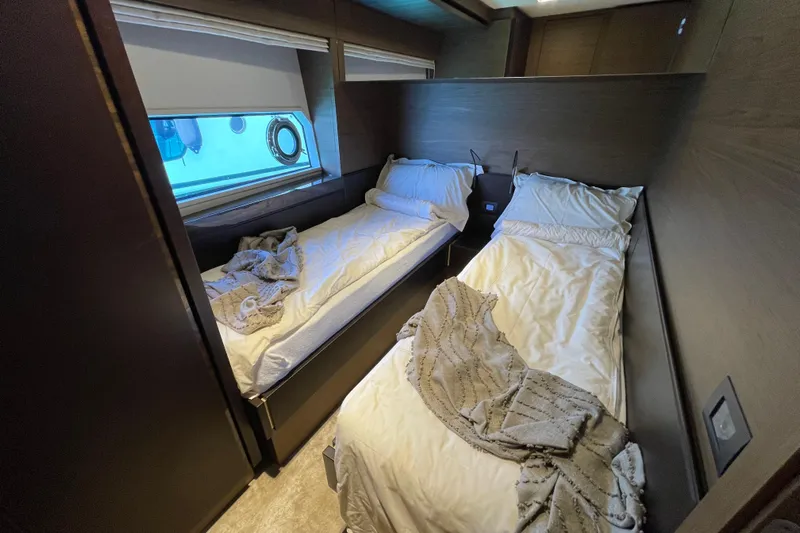  Yacht Photos Pics Twin bedroom interior of 2025 Ferretti Yachts 670, featuring modern design and cozy bedding.