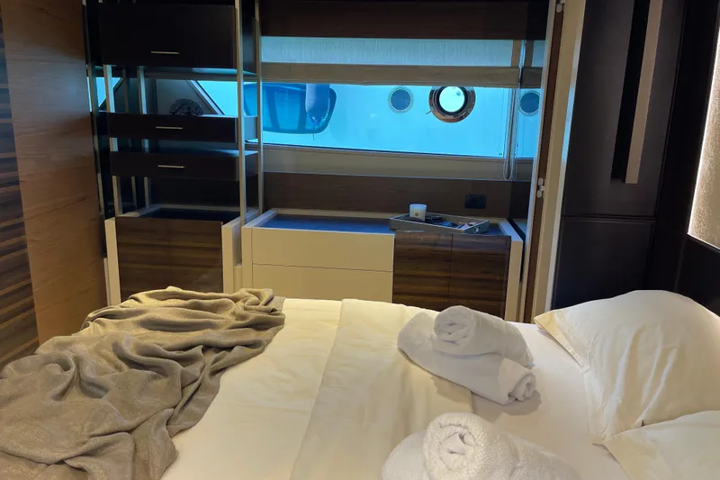  Yacht Photos Pics Luxurious bedroom interior of 2025 Ferretti Yachts 670 with elegant bedding and porthole view.