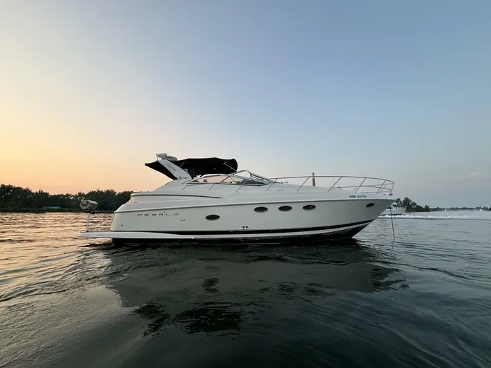  Yacht Photos Pics 2002 Regal 3860 Commodore yacht on calm water at sunset.