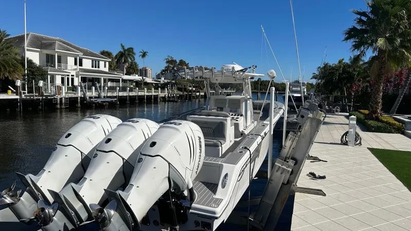  Yacht Photos Pics 2021 Blackwater 36 SF boat docked by waterfront homes, featuring triple outboard engines.