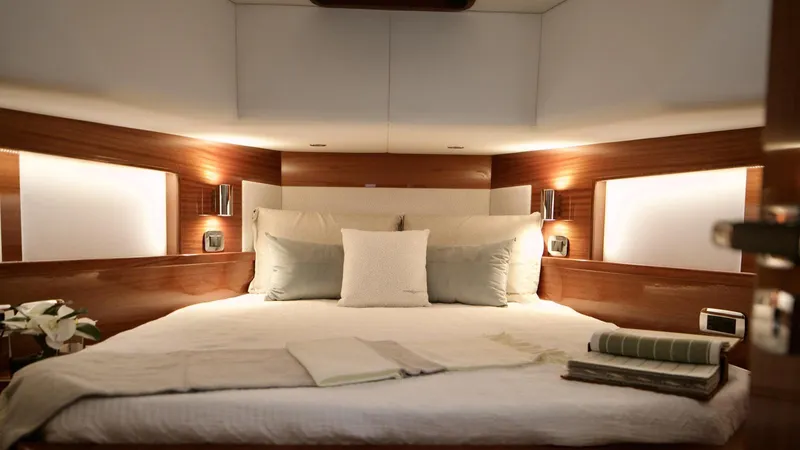 Lancia Aprea Yacht Photos Pics Luxurious bedroom interior of 2024 Lancia Aprea 52 yacht with elegant wood paneling.