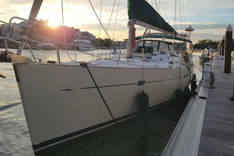 Phantom Yacht Photos Pics 2002 Beneteau 473 sailboat docked at sunset, showcasing sleek design and marina setting.