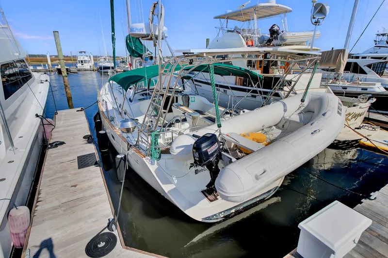 Phantom Yacht Photos Pics Beneteau 473 sailboat, 2002 model, docked with inflatable dinghy attached.