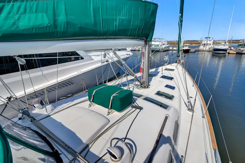 Phantom Yacht Photos Pics 2002 Beneteau 473 sailboat with green covers docked at a marina.