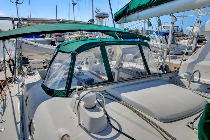 Phantom Yacht Photos Pics 2002 Beneteau 473 sailboat with green canopy, docked in a marina.