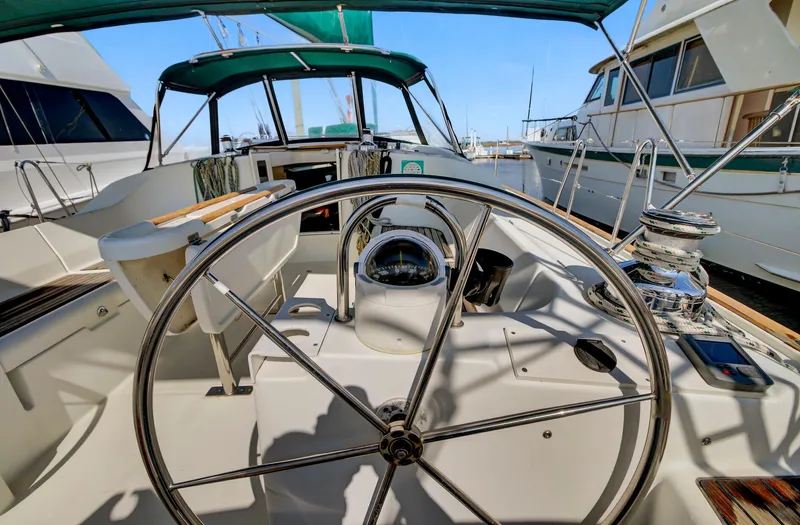 Phantom Yacht Photos Pics Cockpit view of 2002 Beneteau 473 sailboat with steering wheel and navigation instruments.