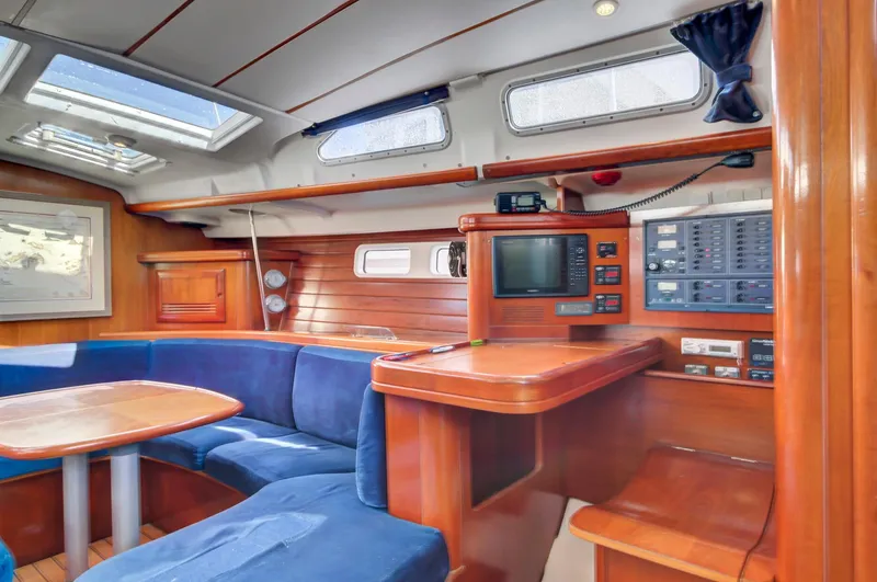 Phantom Yacht Photos Pics Interior of 2002 Beneteau 473 sailboat with blue seating and navigation equipment.