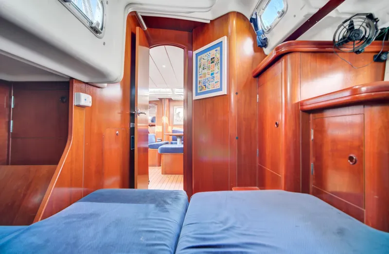 Phantom Yacht Photos Pics Interior of 2002 Beneteau 473 sailboat with wooden finish and blue upholstery.