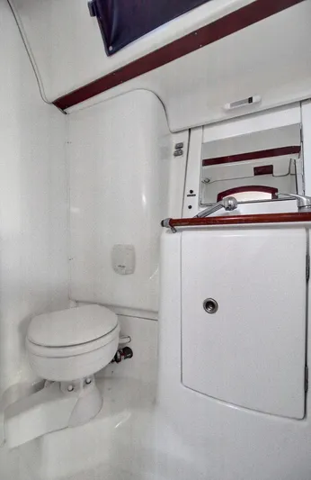 Phantom Yacht Photos Pics Beneteau 473 2002 yacht bathroom with toilet and sink, featuring white and wood accents.