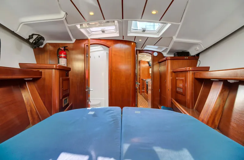Phantom Yacht Photos Pics Interior of 2002 Beneteau 473 yacht with wooden finish and blue cushions.