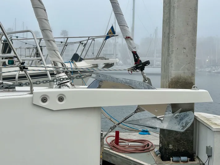 Painkiller Yacht Photos Pics Bavaria C50 yacht docked in a foggy marina, showcasing anchor and rigging.