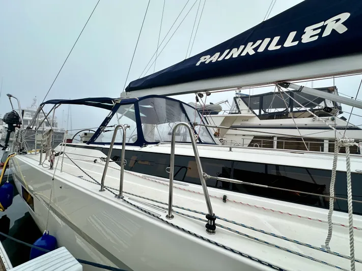 Painkiller Yacht Photos Pics 2020 Bavaria C50 sailboat docked, featuring sleek design and "Painkiller" on the sail cover.