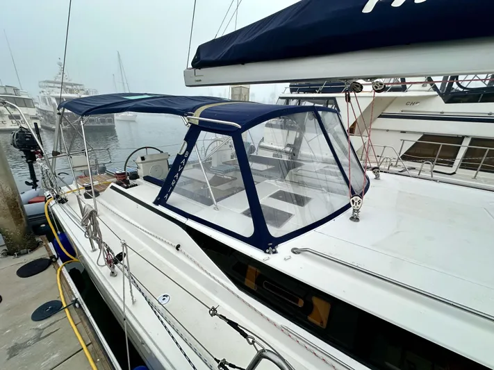 Painkiller Yacht Photos Pics 2020 Bavaria C50 yacht docked at marina, featuring blue canopy and sleek design.