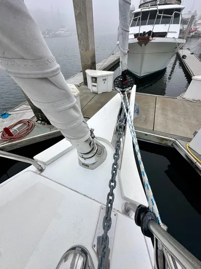 Painkiller Yacht Photos Pics Bavaria C50 yacht docked at marina, showcasing anchor chain and deck details.