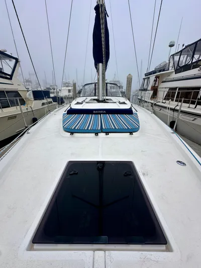 Painkiller Yacht Photos Pics 2020 Bavaria C50 yacht deck with striped cushions, docked among other boats.
