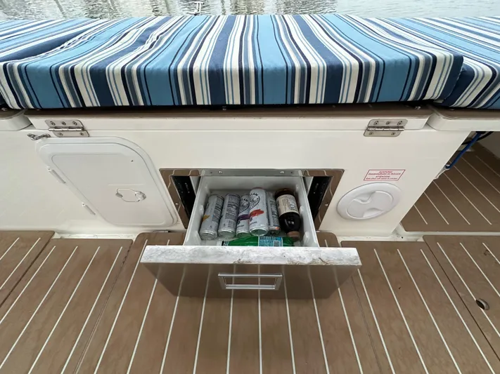 Painkiller Yacht Photos Pics Bavaria C50 yacht with striped seating and open drawer containing beverages, 2020 model.