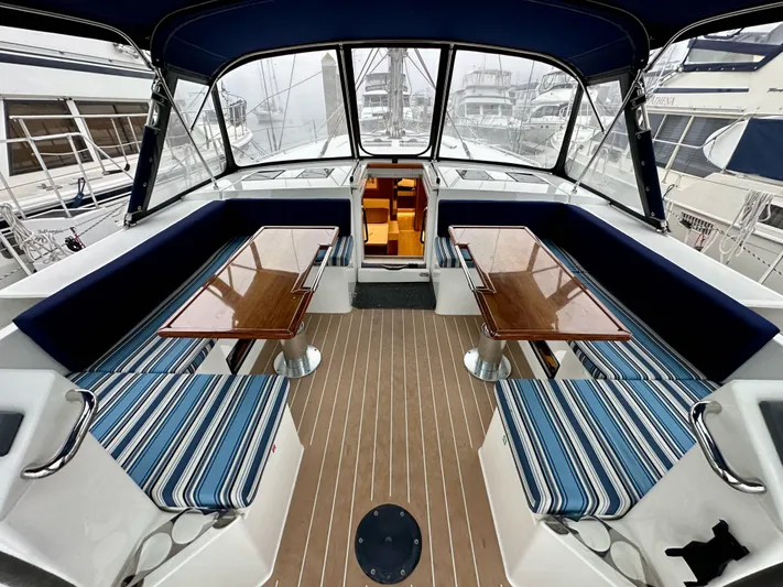 Painkiller Yacht Photos Pics Interior of 2020 Bavaria C50 yacht with striped seating and wooden tables.