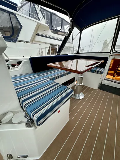 Painkiller Yacht Photos Pics 2020 Bavaria C50 yacht interior with striped seating and wooden table.