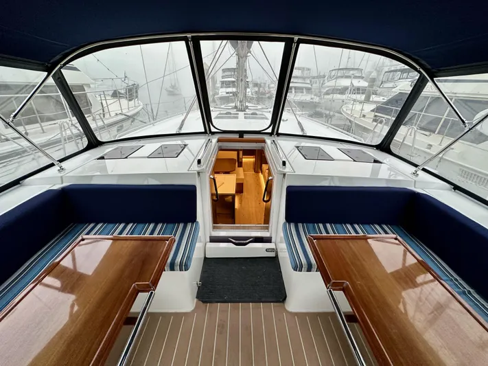 Painkiller Yacht Photos Pics Interior view of 2020 Bavaria C50 yacht with elegant seating and wooden tables.