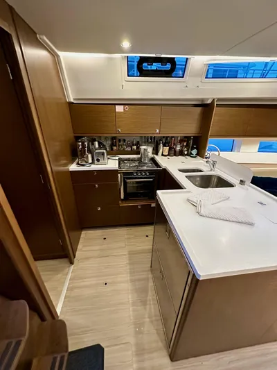 Painkiller Yacht Photos Pics Modern kitchen interior of 2020 Bavaria C50 yacht with wooden cabinetry and appliances.
