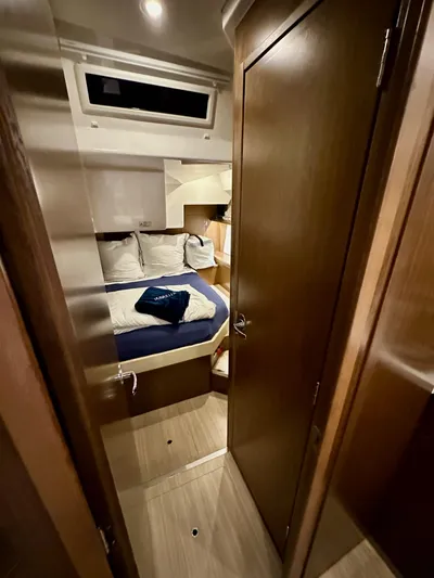 Painkiller Yacht Photos Pics Interior cabin of 2020 Bavaria C50 yacht, featuring cozy bed and wooden furnishings.